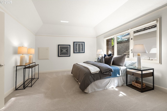 carpeted bedroom featuring baseboards and lofted ceiling