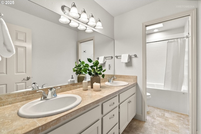 bathroom featuring toilet, double vanity, and shower / bath combo with shower curtain