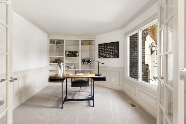 office with a decorative wall, carpet flooring, a wainscoted wall, crown molding, and french doors