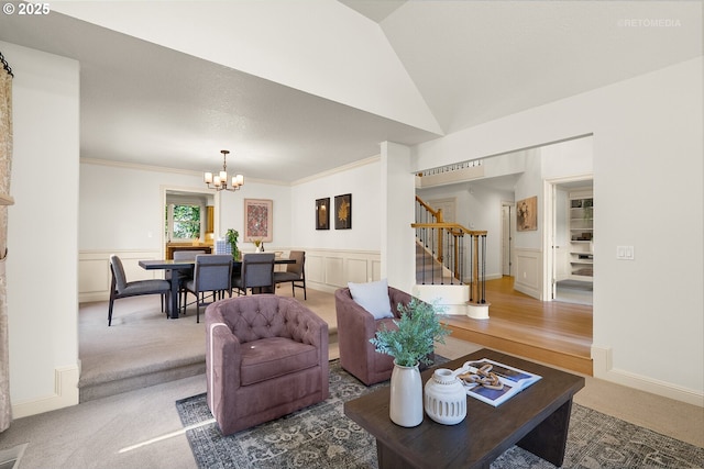 living area featuring stairs, a chandelier, carpet, crown molding, and wainscoting