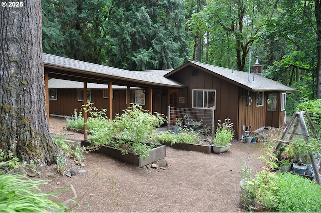 89016 Bridge St, Springfield, OR 97478 - view of front of home featuring a vegetable garden, a chimney, roof with shingles, and board and batten siding