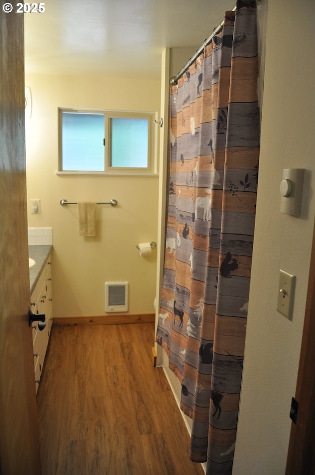89016 Bridge St, Springfield, OR 97478 - bathroom featuring wood finished floors, vanity, heating unit, and a shower with shower curtain