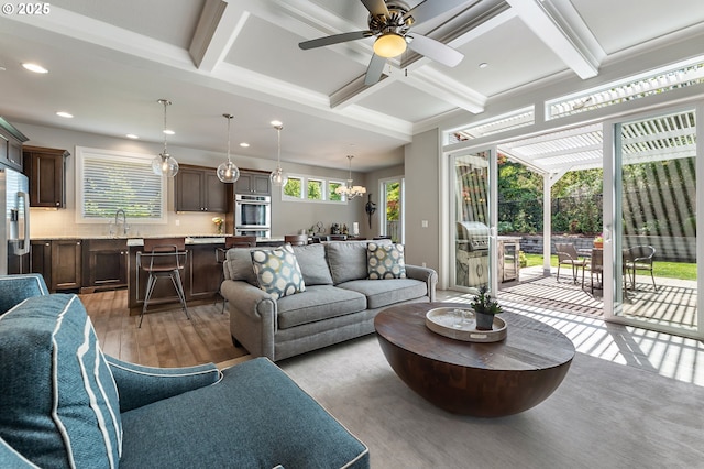 living room with beamed ceiling, light wood-style floors, ceiling fan, recessed lighting, and coffered ceiling