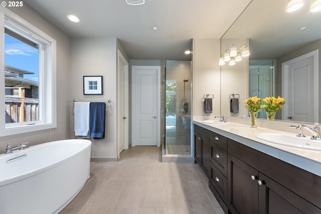 full bathroom featuring a sink, tile patterned flooring, a shower stall, and double vanity