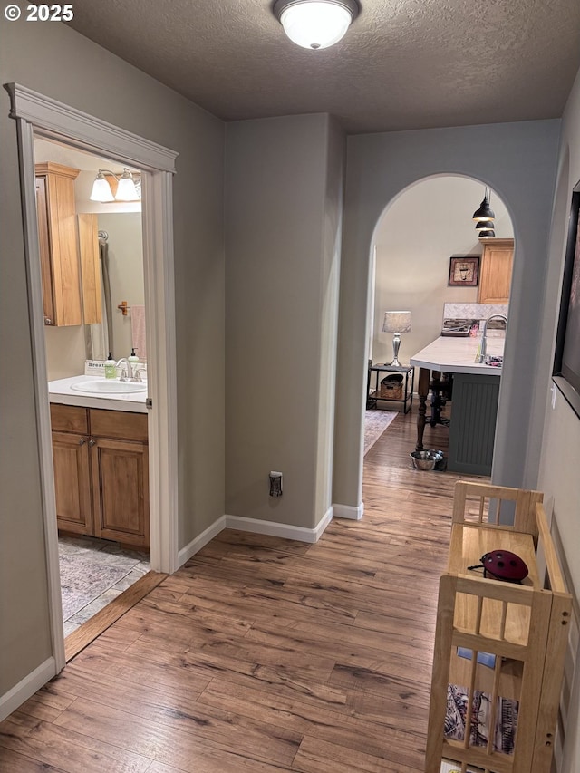 1809 Balm St, Baker City, OR 97814 - hallway with a textured ceiling, arched walkways, and wood finished floors