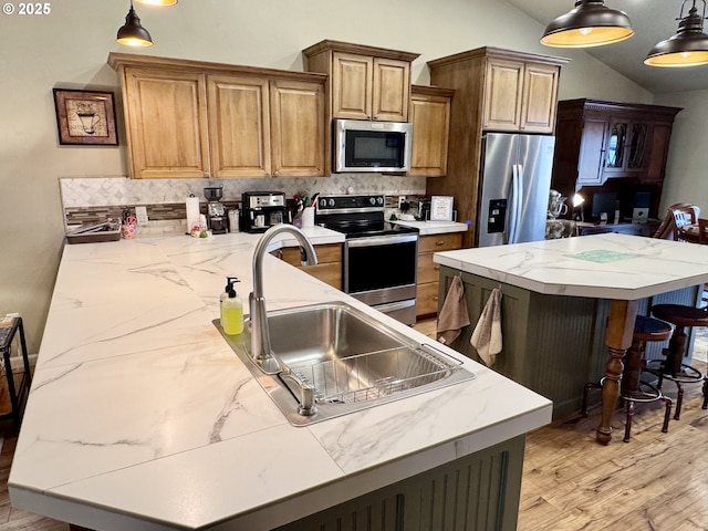 1809 Balm St, Baker City, OR 97814 - kitchen with stainless steel appliances, vaulted ceiling, decorative backsplash, light wood-type flooring, and a kitchen island