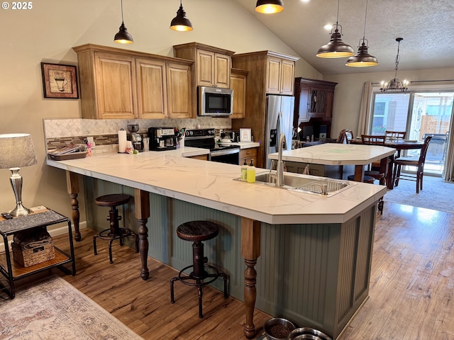 1809 Balm St, Baker City, OR 97814 - kitchen with appliances with stainless steel finishes, light countertops, a peninsula, a kitchen bar, and backsplash