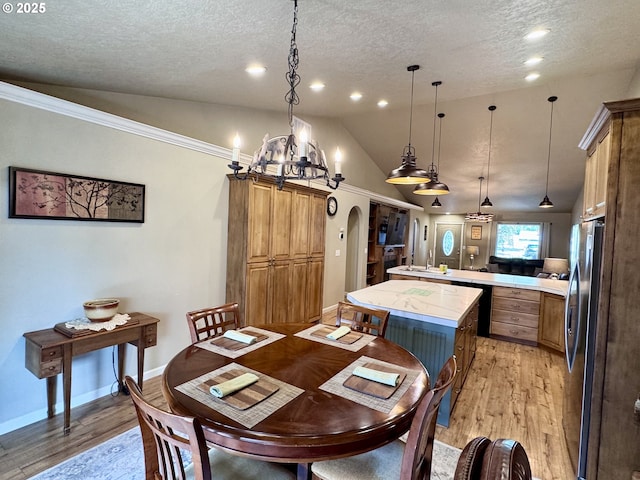1809 Balm St, Baker City, OR 97814 - dining area with lofted ceiling, light wood-style floors, a textured ceiling, a chandelier, and arched walkways