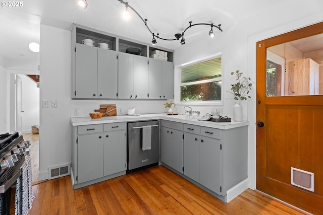 6736 N Haight Ave, Portland, OR 97217 - kitchen with appliances with stainless steel finishes, gray cabinets, a sink, light wood finished floors, and light countertops