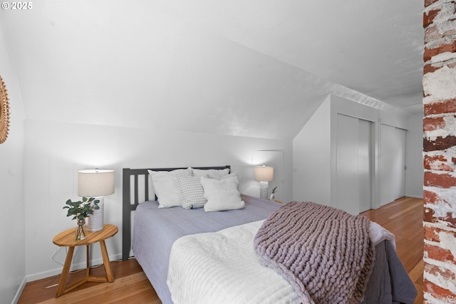 6736 N Haight Ave, Portland, OR 97217 - bedroom featuring wood finished floors, vaulted ceiling, and multiple closets