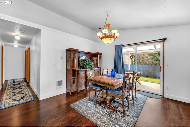 dining area with a chandelier, wood finished floors, visible vents, and baseboards