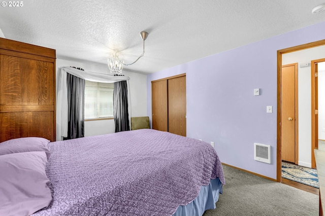 carpeted bedroom featuring baseboards, a textured ceiling, visible vents, and a closet