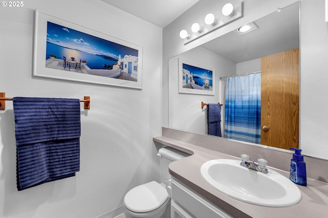 bathroom featuring curtained shower, vanity, and toilet