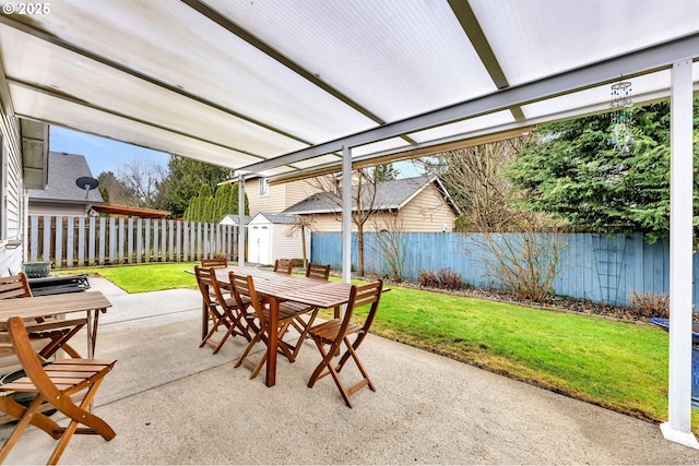 view of patio / terrace featuring a storage shed, outdoor dining area, an outdoor structure, and a fenced backyard