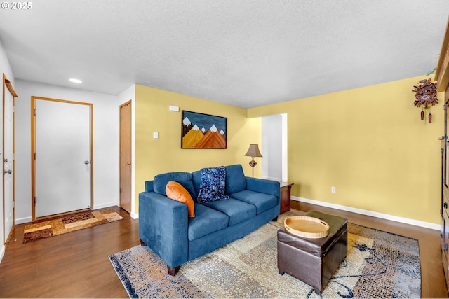 living area with recessed lighting, a textured ceiling, baseboards, and wood finished floors