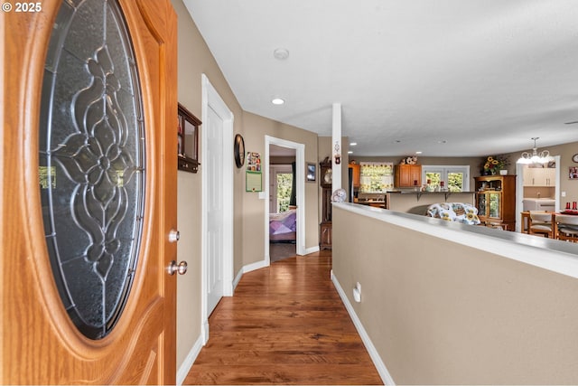 entryway with dark wood-style floors, recessed lighting, a chandelier, and baseboards