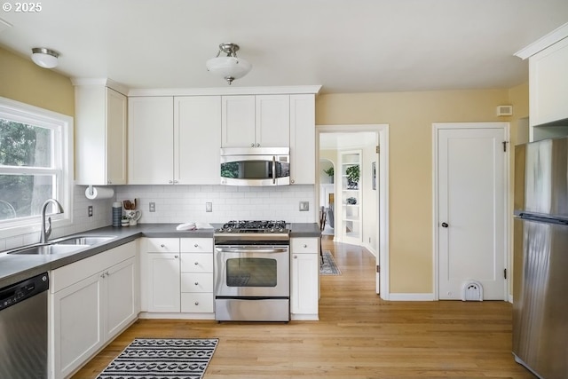 8100 SW 6th Ave, Portland, OR 97219 - kitchen featuring stainless steel appliances, a sink, decorative backsplash, light wood-style flooring, and white cabinets