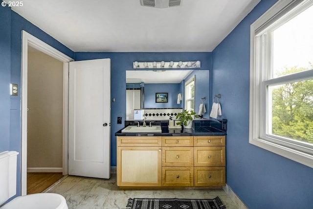 8100 SW 6th Ave, Portland, OR 97219 - bathroom with vanity, healthy amount of natural light, decorative backsplash, and baseboards