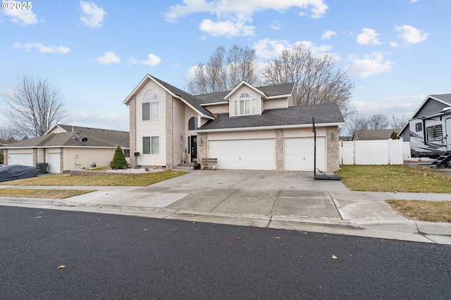 traditional home with brick siding, fence, a garage, driveway, and a front lawn