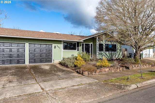 single story home with a garage, concrete driveway, and roof with shingles