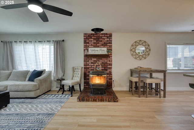 156 1st Ave, Coos Bay, OR 97420 - living room with a wood stove, a ceiling fan, wood finished floors, and baseboards