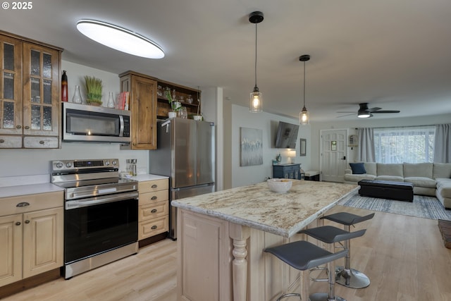 156 1st Ave, Coos Bay, OR 97420 - kitchen with stainless steel appliances, open shelves, light wood-style flooring, ceiling fan, and a kitchen island