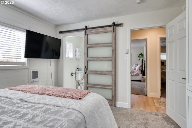 156 1st Ave, Coos Bay, OR 97420 - bedroom with multiple windows, a barn door, carpet, a textured ceiling, and heating unit