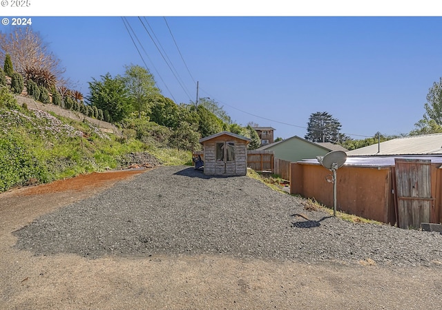 156 1st Ave, Coos Bay, OR 97420 - view of yard featuring fence, a storage unit, and an outbuilding