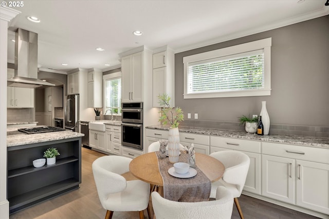 kitchen featuring white cabinets, island exhaust hood, light stone counters, and open shelves