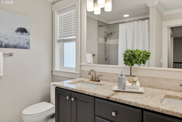 full bathroom featuring crown molding, tiled shower, a sink, and double vanity