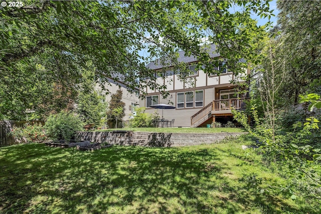 rear view of house with a deck, a yard, and stairway