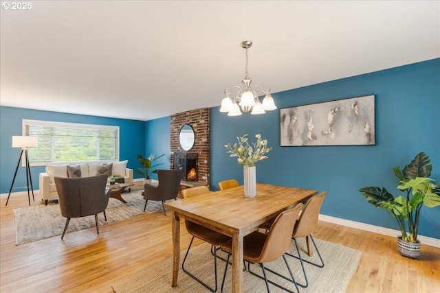 11995 SW 119th Ave, Portland, OR 97223 - dining area featuring wood finished floors, a chandelier, and a fireplace