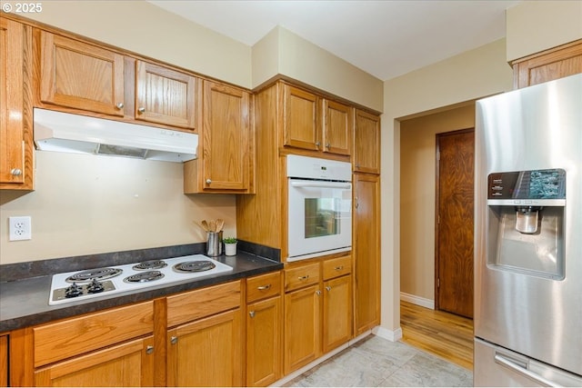 11995 SW 119th Ave, Portland, OR 97223 - kitchen with white appliances, under cabinet range hood, dark countertops, and brown cabinets