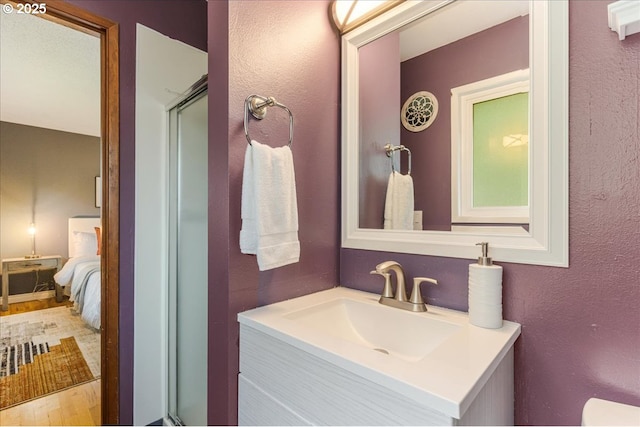 11995 SW 119th Ave, Portland, OR 97223 - bathroom with vanity, a shower with door, a textured wall, wood finished floors, and ensuite bathroom