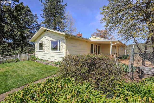 383 Little Valley Rd, Roseburg, OR 97471 - view of side of home featuring fence, a chimney, and a lawn