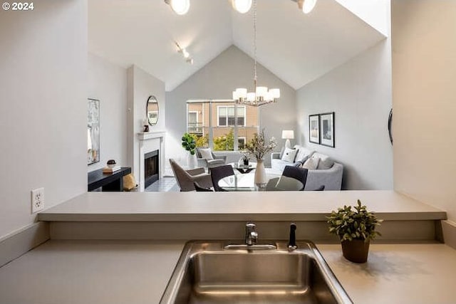 1710 S Harbor Way Unit C405, Portland, OR 97201 - kitchen with a sink, open floor plan, a fireplace, a chandelier, and high vaulted ceiling