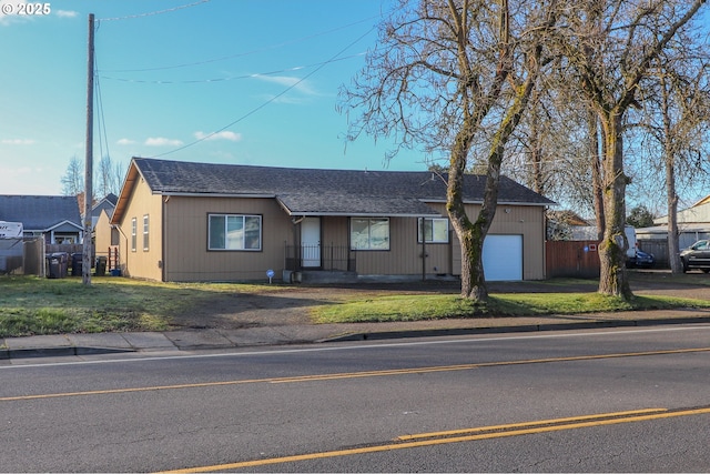 ranch-style house featuring a garage and a front lawn