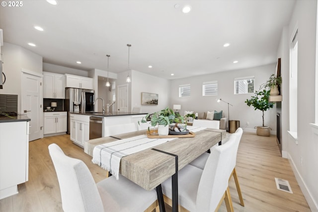 dining area with light wood-type flooring and sink