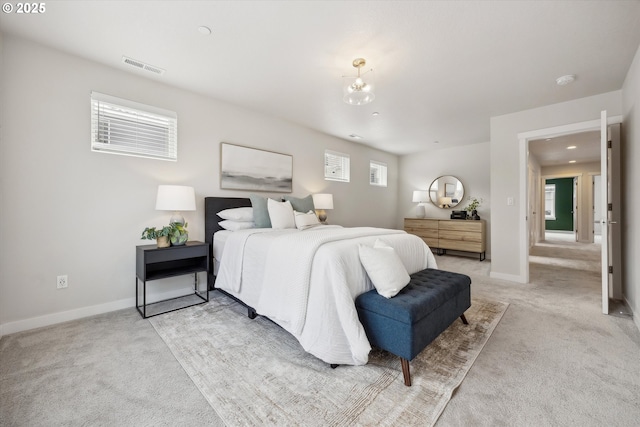 bedroom featuring light carpet, multiple windows, and a notable chandelier