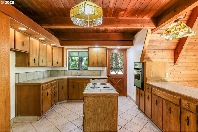 18020 SW Neugebauer Rd, Hillsboro, OR 97123 - kitchen with stainless steel oven, wood ceiling with exposed beams, tile countertops, a sink, and a kitchen island