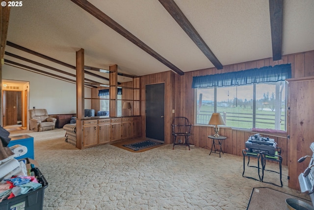 interior space featuring lofted ceiling with beams, a textured ceiling, and wooden walls