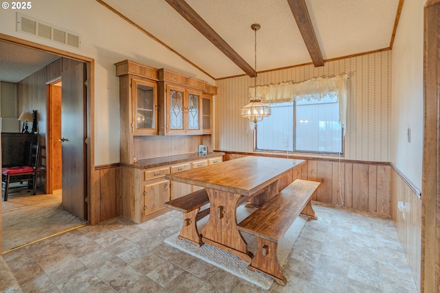 dining area featuring visible vents, a wainscoted wall, wallpapered walls, an inviting chandelier, and lofted ceiling with beams