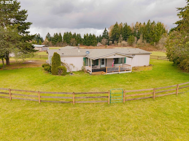 exterior space featuring fence private yard, a deck, a lawn, and a rural view