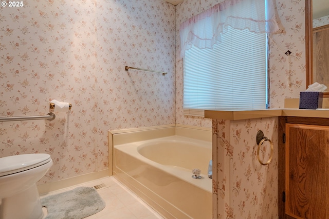 full bathroom with tile patterned flooring, toilet, wallpapered walls, and a garden tub