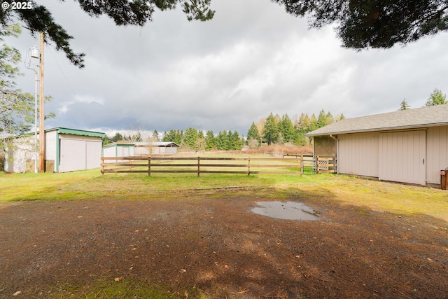 view of yard with an outbuilding, a pole building, and fence