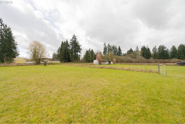 view of yard featuring a rural view and fence