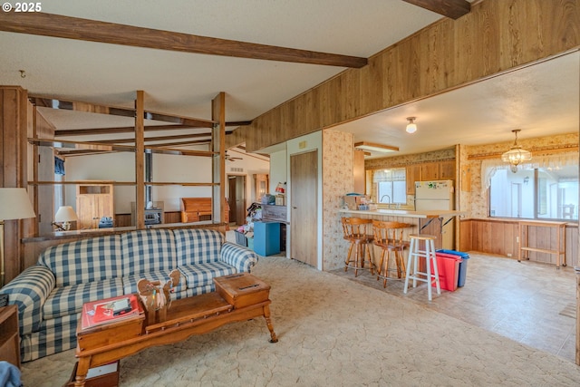 living area with lofted ceiling with beams and wood walls