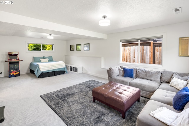 carpeted bedroom featuring a textured ceiling and baseboards