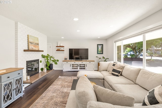 living room with dark wood-style floors, a fireplace, recessed lighting, a textured ceiling, and baseboards