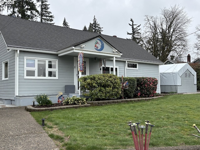 view of front of house featuring a front yard and roof with shingles